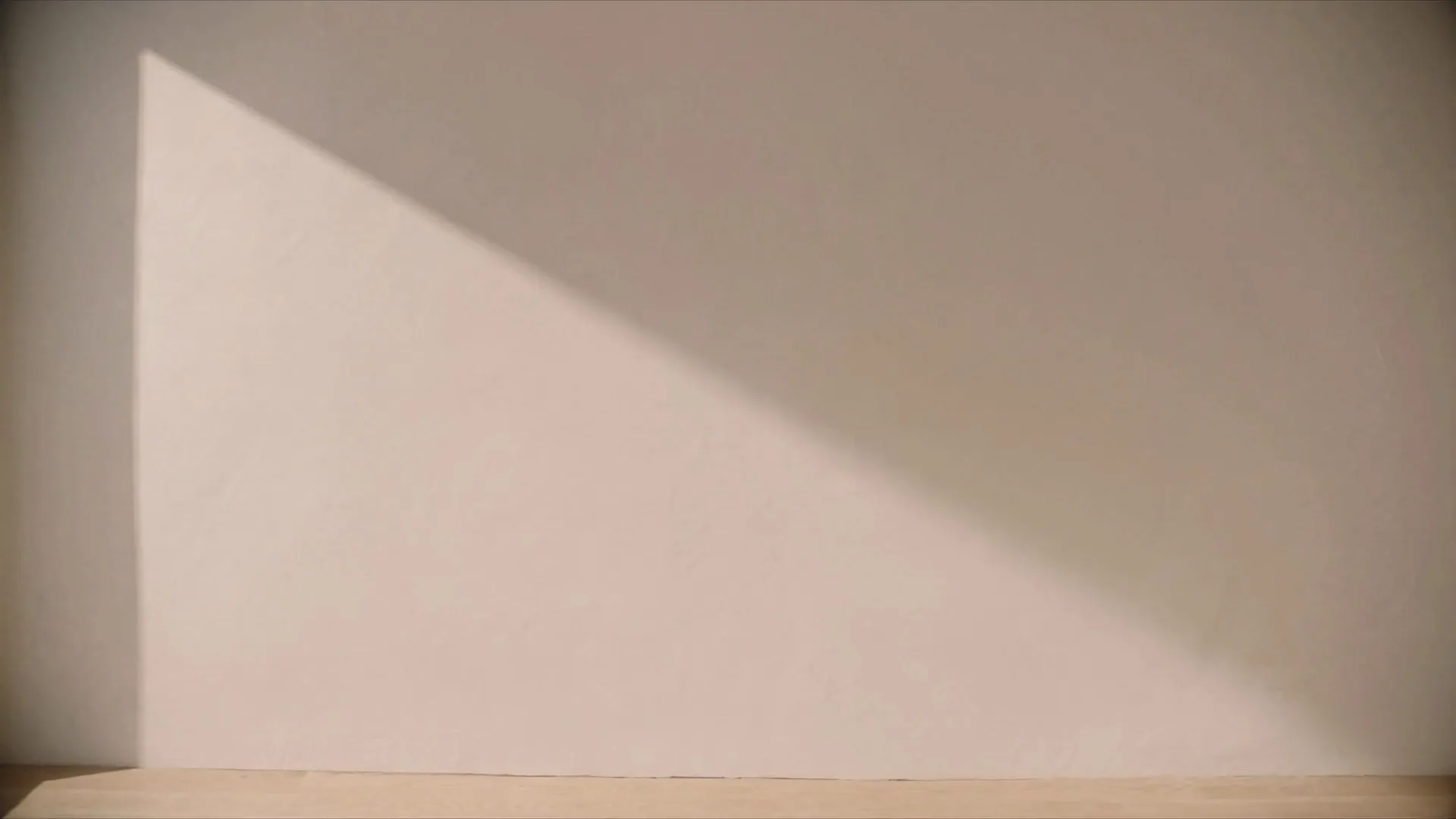 Un mur enduit, parfaitement lisse, traversé par un rayon de soleil rasant